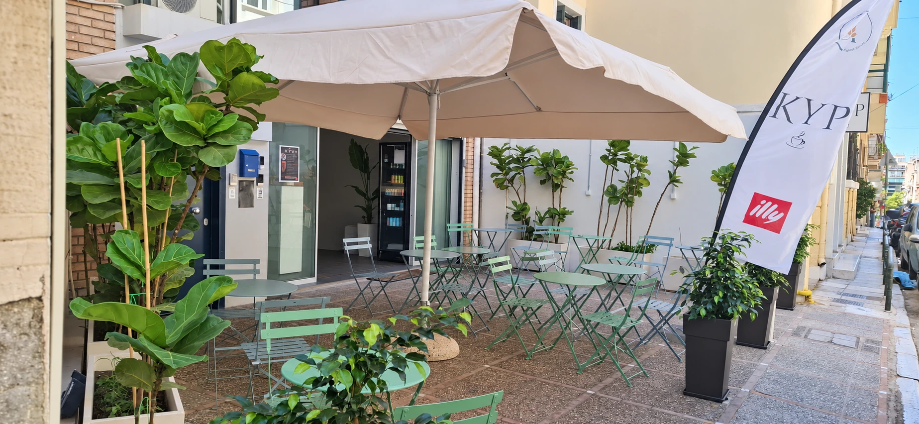 Outdoor seating at KYP Café with the KYP and illy flag